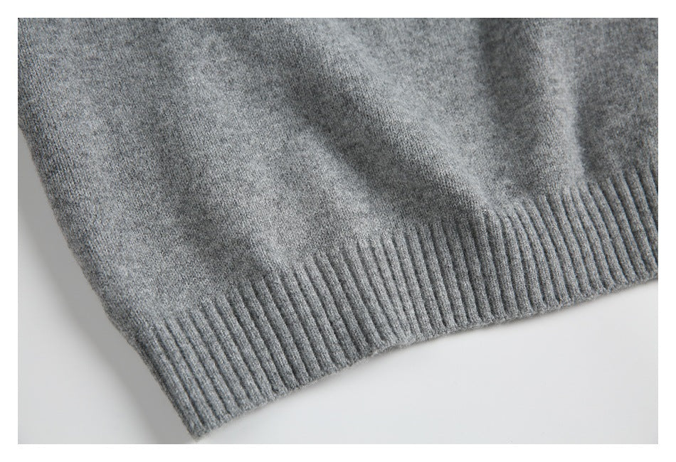 Close-up of the heather gray knit garment's ribbed hem and knit texture.