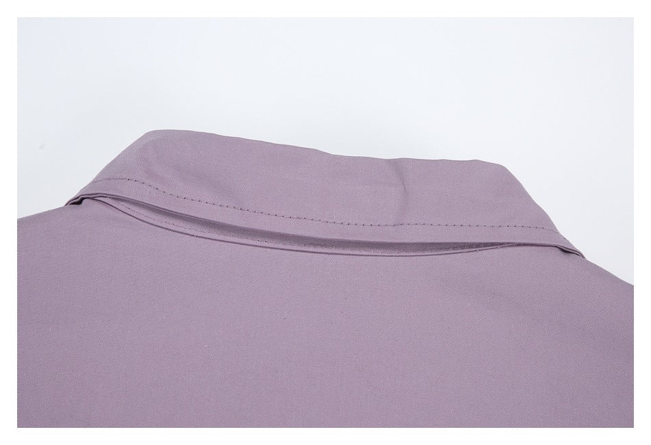 Close-up of a pointed collar and stitching on a muted lavender garment.