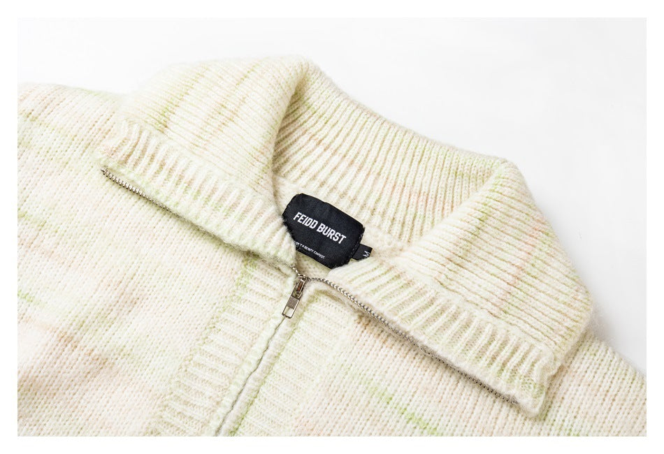 Close-up of the ivory sweater's ribbed collar, metal front zipper, knit texture, and sewn neck label.