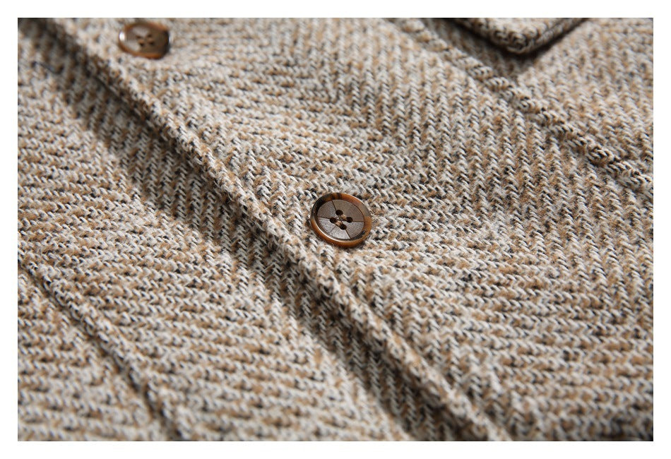 Close-up of brown buttons on the front of a tan and brown herringbone garment.