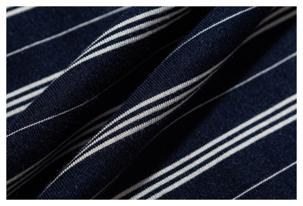 Close-up of navy fabric with thin white horizontal stripes and folded ridges.