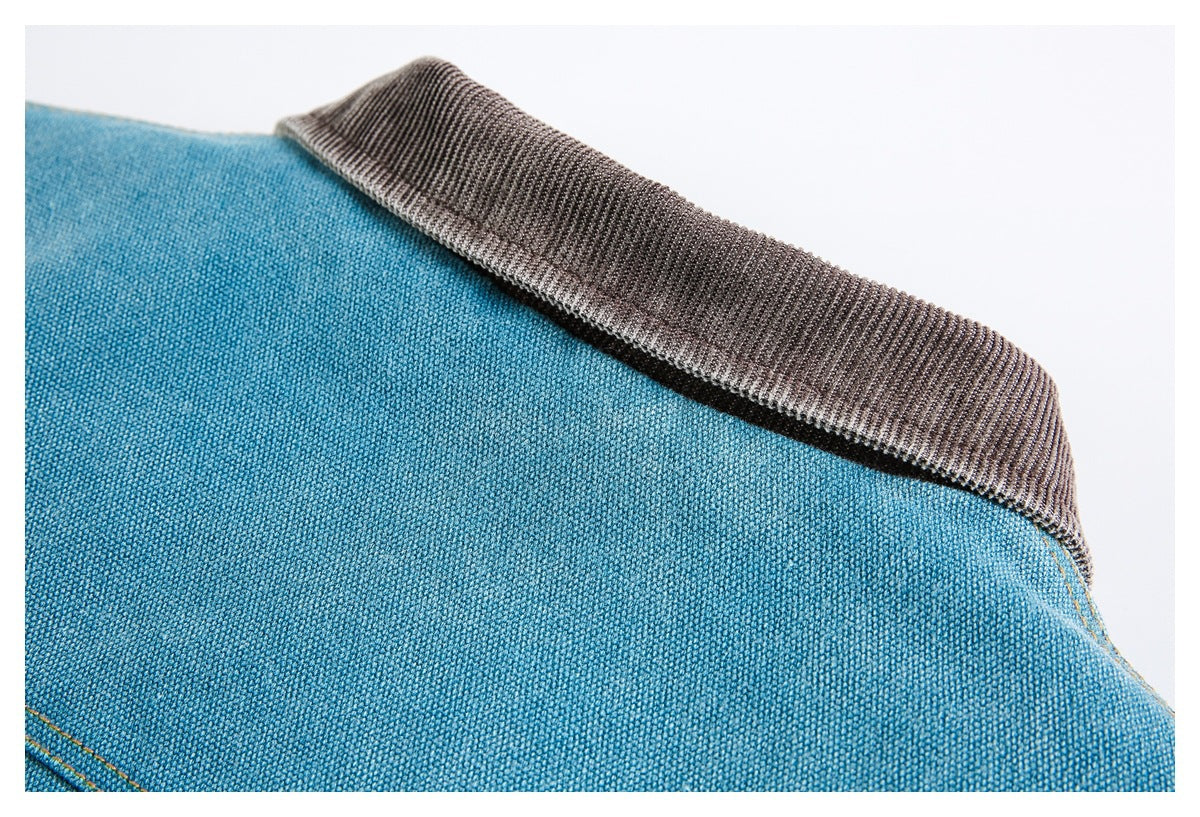 Close-up of a blue woven garment with a wide dark gray ribbed collar.