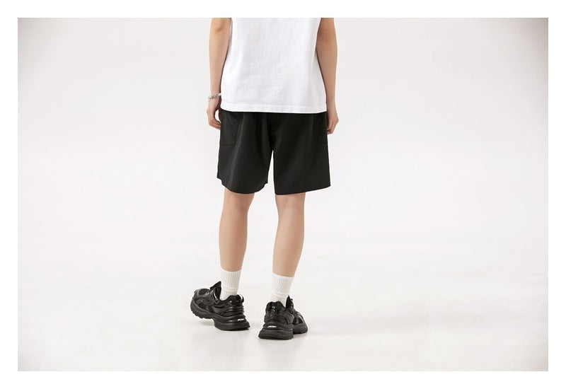 Model wearing black shorts, shown from the back with a rear pocket visible.