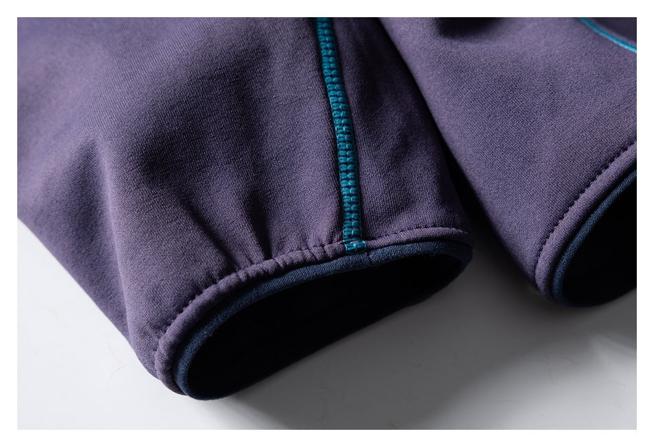 Close-up of a purple sleeve cuff with teal overlock stitching and a dark bound edge.
