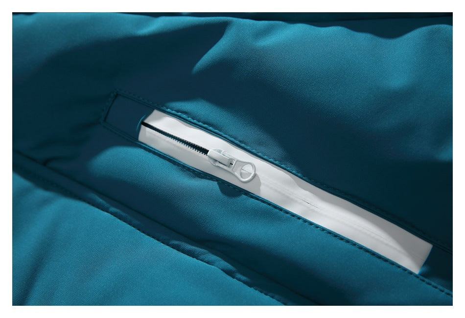 Close-up of a white zipper set into teal jacket fabric.
