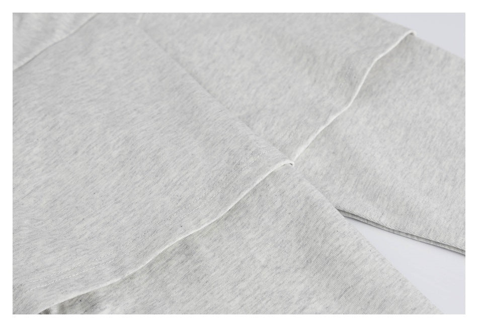 Close-up of light gray heather garment panels and stitched seams.