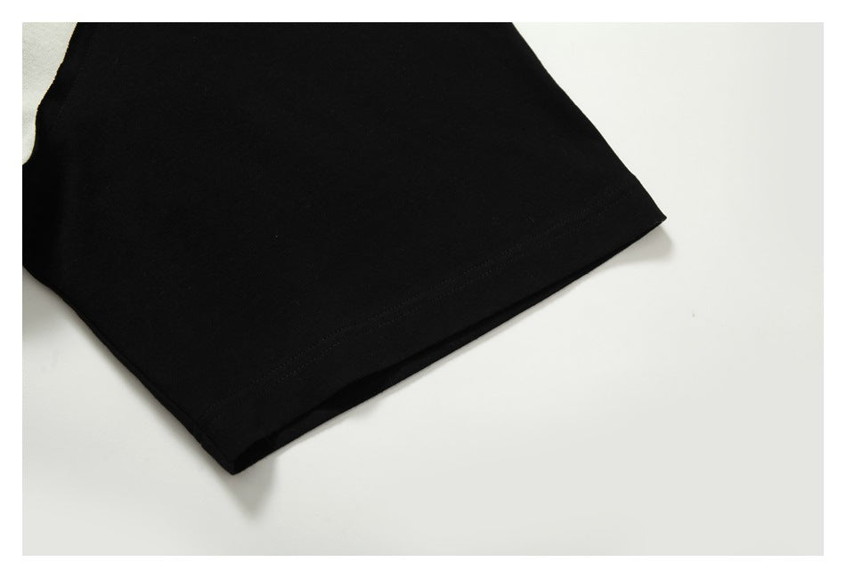Close-up of a black sleeve and its stitched hem against a white background.
