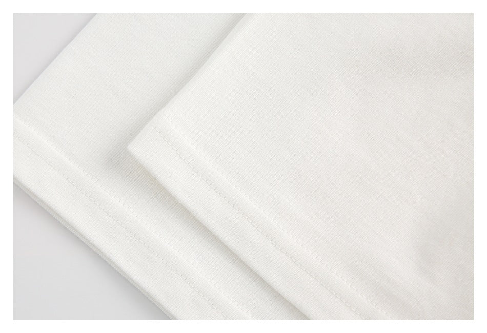 Close-up of stitching along the hem of white T-shirt fabric.