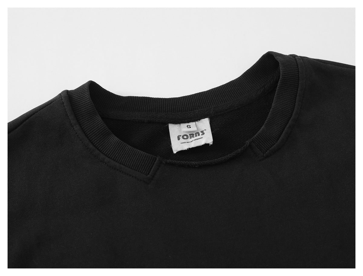Close-up of a black sweatshirt neckline, ribbed collar, and sewn-in brand label.