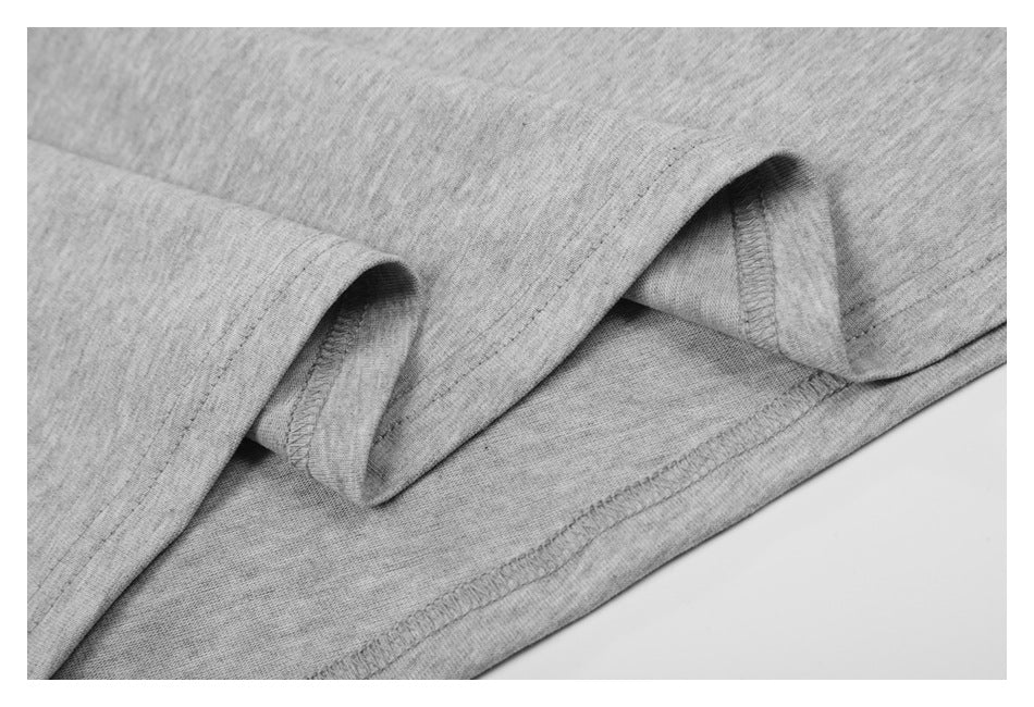 Close-up of light gray knit fabric folded to show the garment's stitched hem.