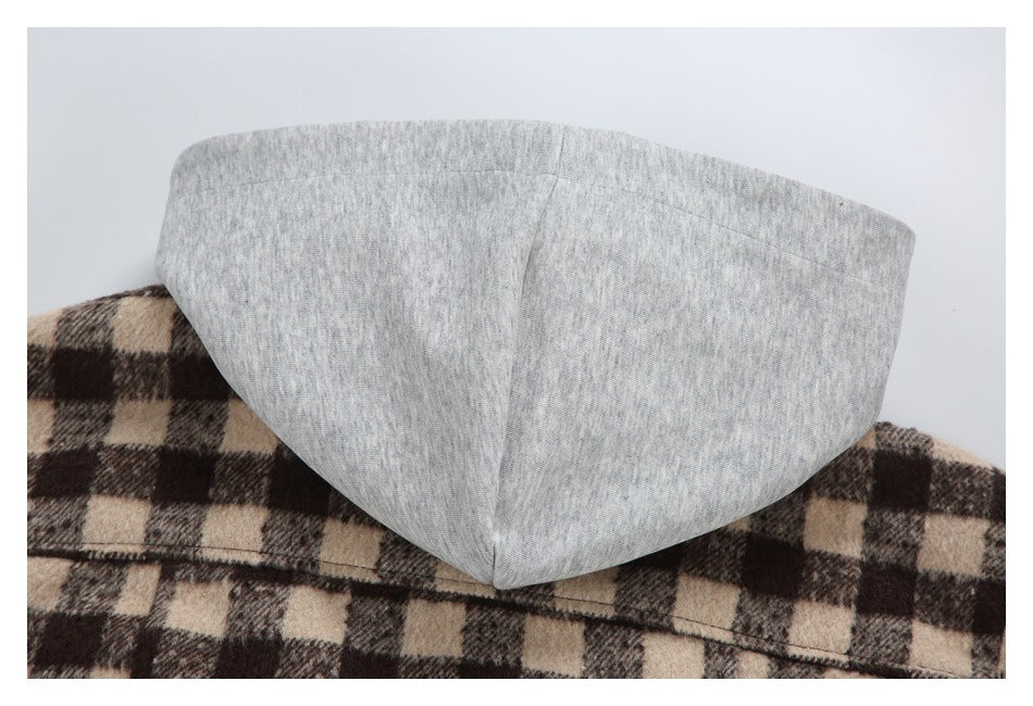 Close-up of a light gray hood lining against a brown and beige plaid garment.