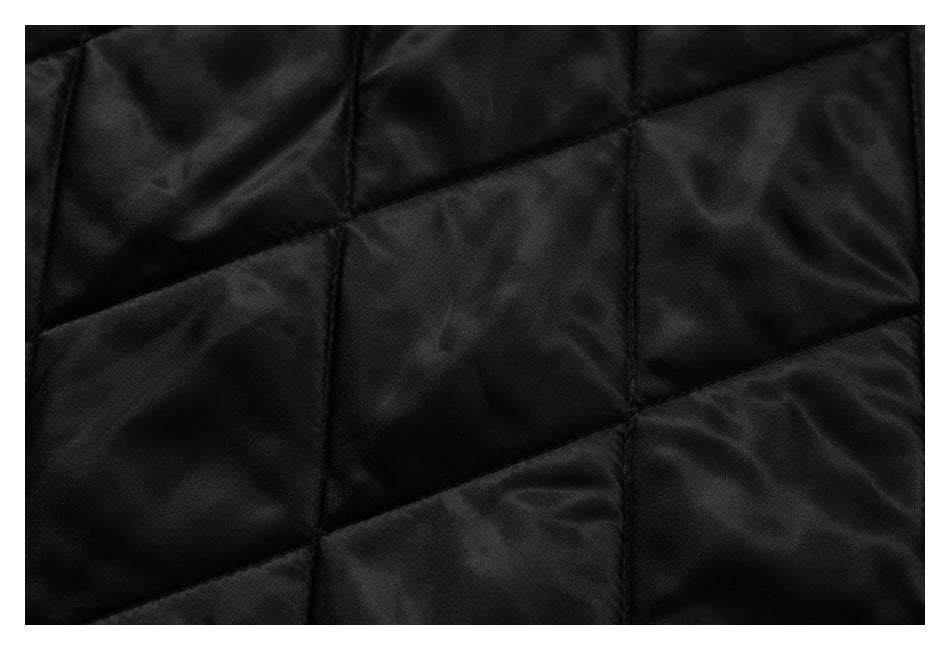 Close-up of black quilted fabric with large stitched geometric panels.