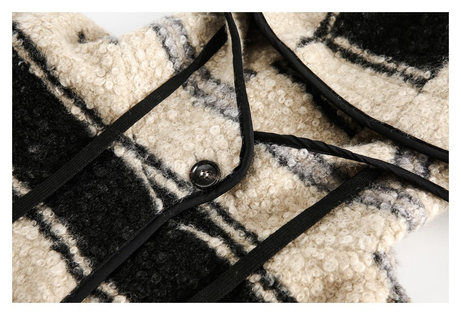 Close-up of the jacket’s striped front, black-trimmed placket, and a dark button.