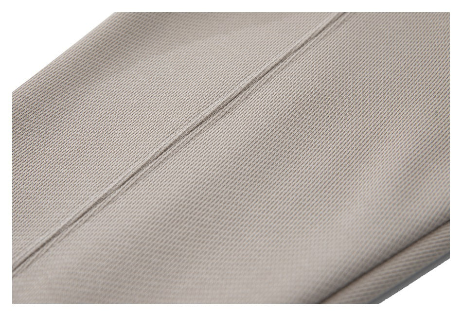 Close-up of beige knit fabric showing a diagonal stitched seam.