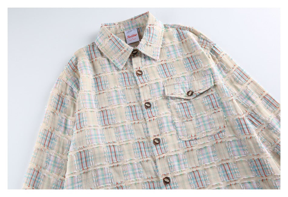 Front view of a cream plaid patchwork shirt with a pointed collar, dark buttons, one chest pocket, and frayed seams.