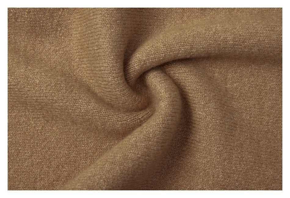 Close-up of camel-brown knit fabric draped in a swirl, showing its fine texture.