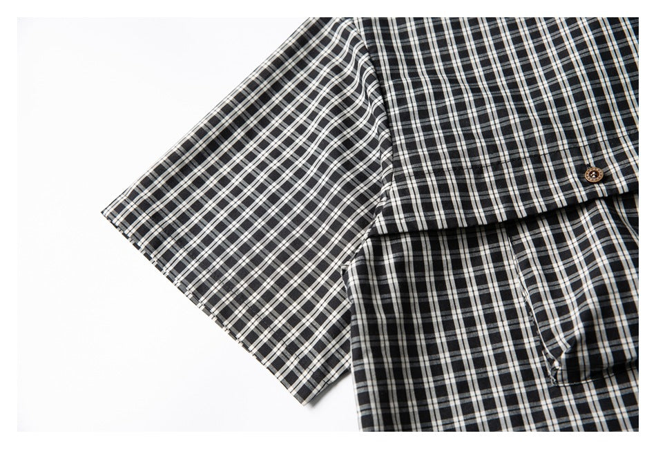 Close-up of the short sleeve and chest pocket of a black-and-white checked shirt.