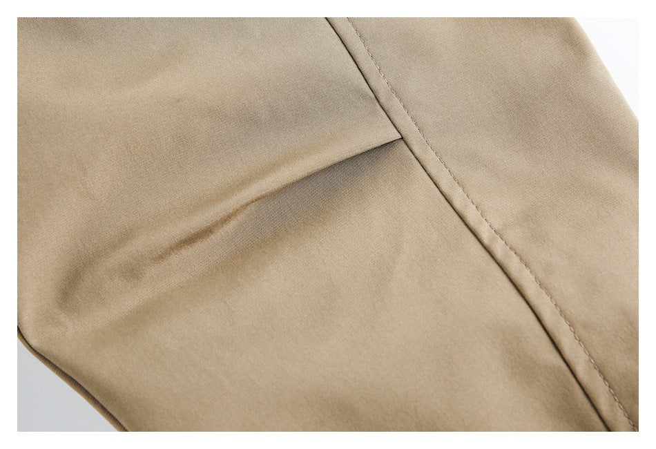Close-up of tan garment fabric showing a folded seam and parallel rows of stitching.