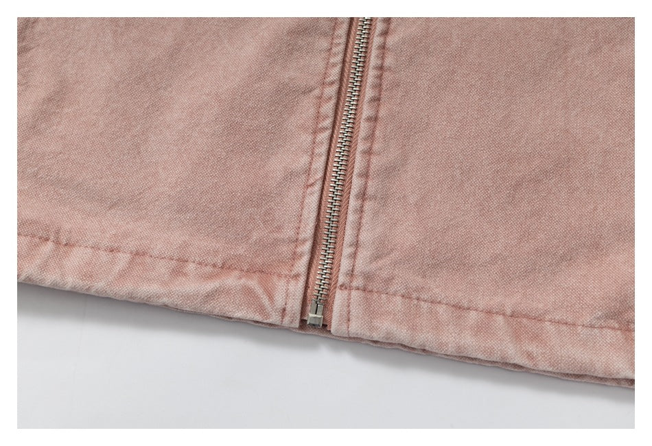 Close-up of a metal zipper and stitched hem on dusty rose fabric.