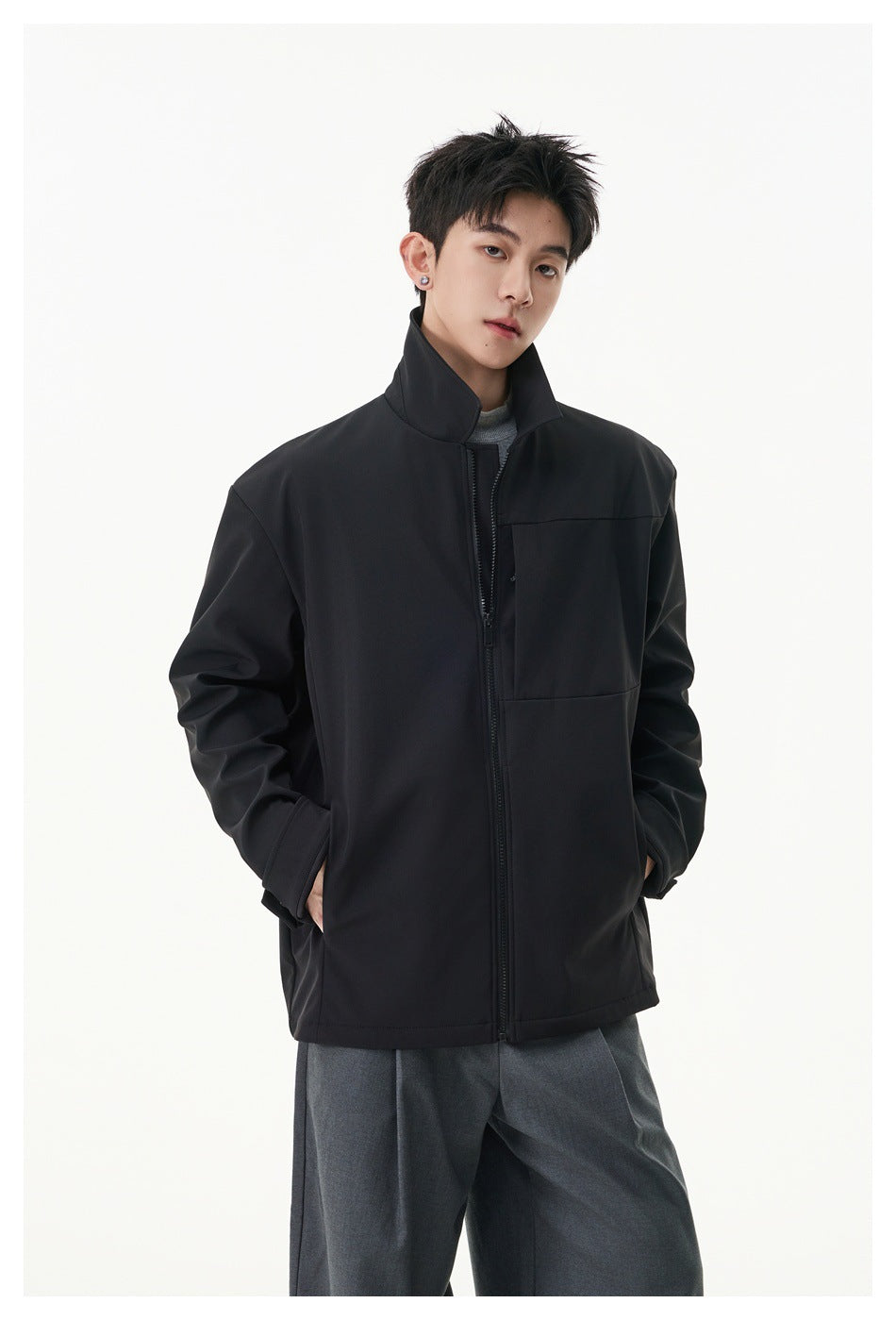 Model wearing a black zip-front jacket with a high stand collar, long sleeves and front pockets.