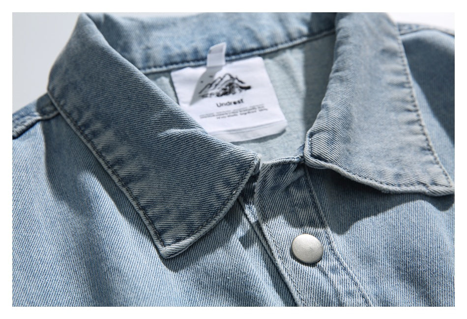 Close-up of the denim jacket collar, snap button, and sewn-in neck label.