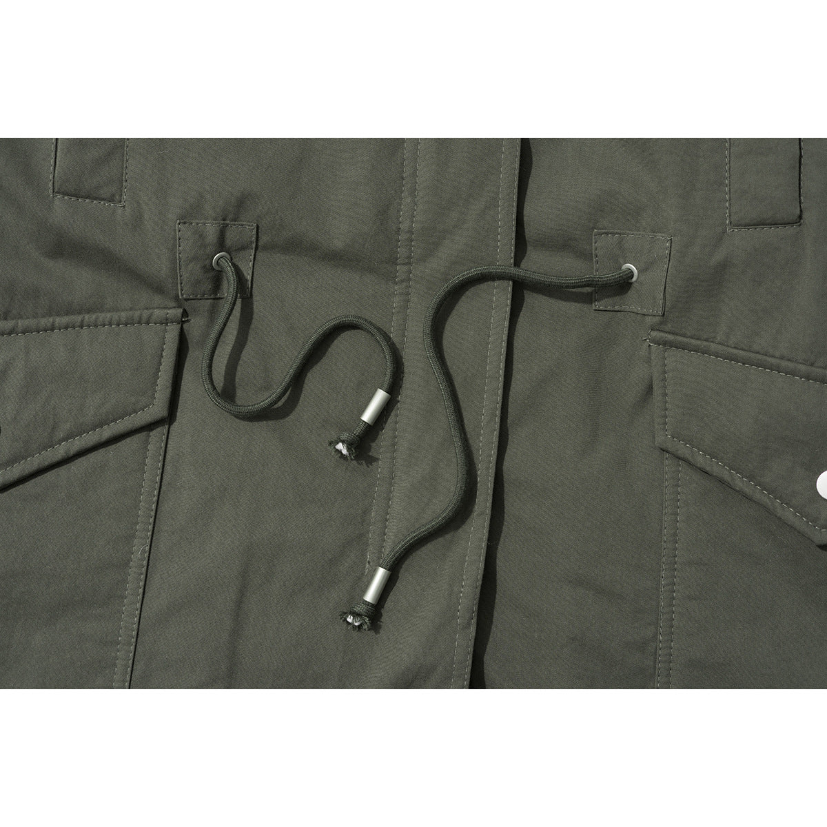 Close-up of an olive jacket front with a drawcord waist and large flap pockets.