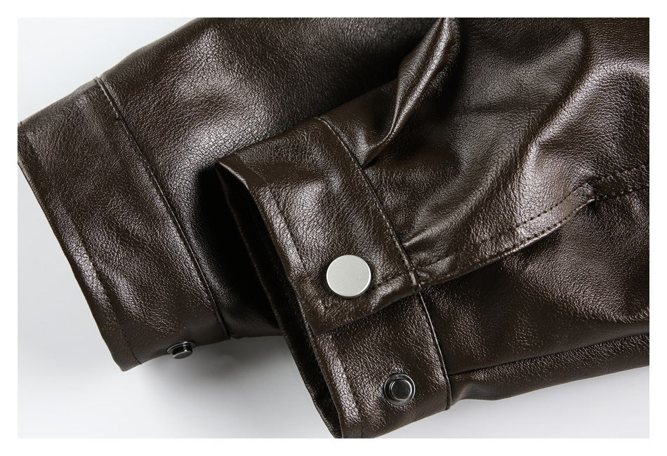 Close-up of a dark brown jacket sleeve cuff with snap-button closures and stitched seams.