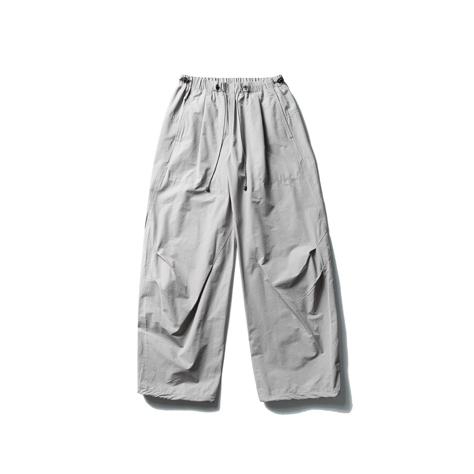 Light gray wide-leg parachute pants with drawcord elastic waistband, flat lay front view