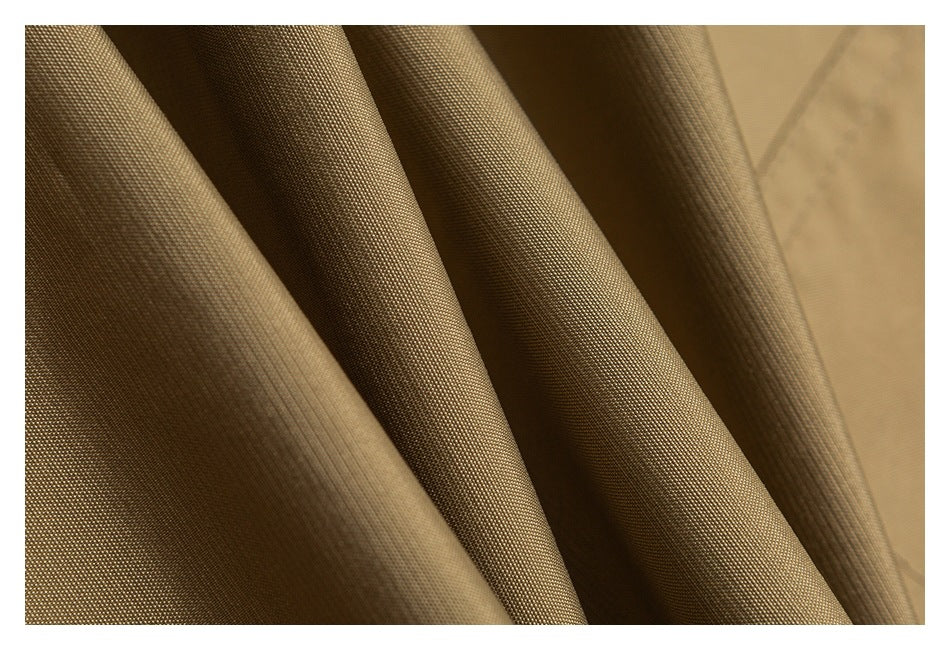 Macro view of tan fabric draped in folds, showing its fine woven texture.