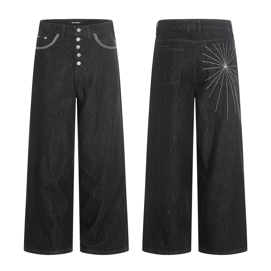 Front and back views of black wide-leg jeans with a button fly, white contrast stitching, and a radiating back motif.