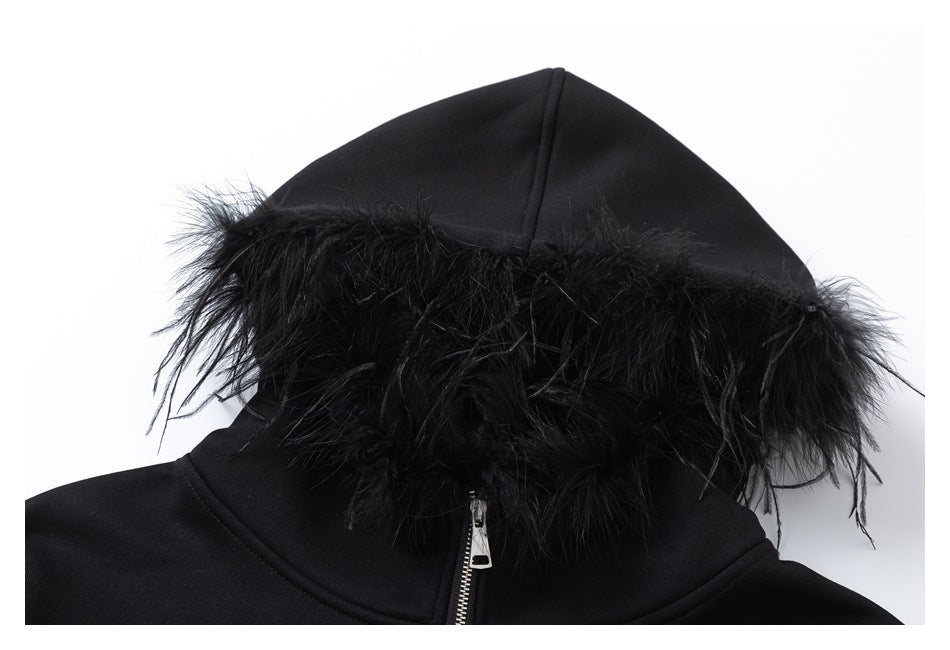 Close-up of the black sweatshirt's hood, edged with black feather-like trim, with a silver zipper below.