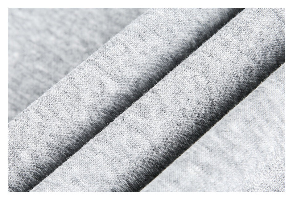 Close-up of folded light gray heathered fabric showing its textured surface.
