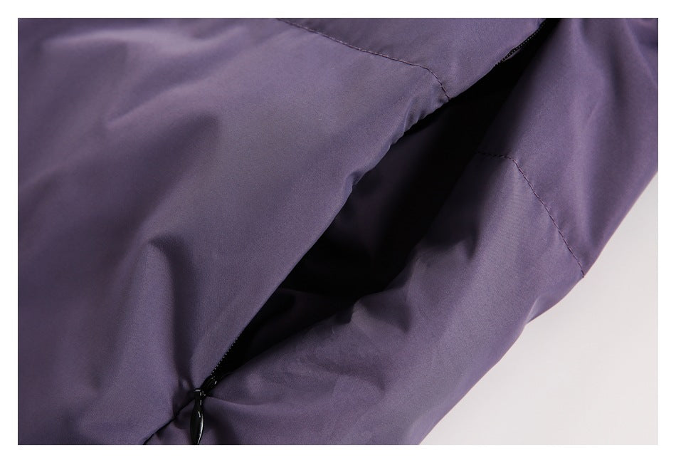 Close-up of an open black zip pocket in a purple garment.