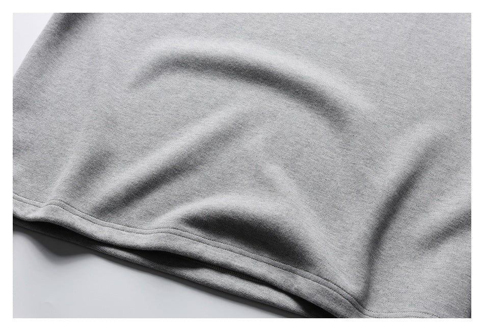 Close-up of the straight stitched hem on a light gray garment.