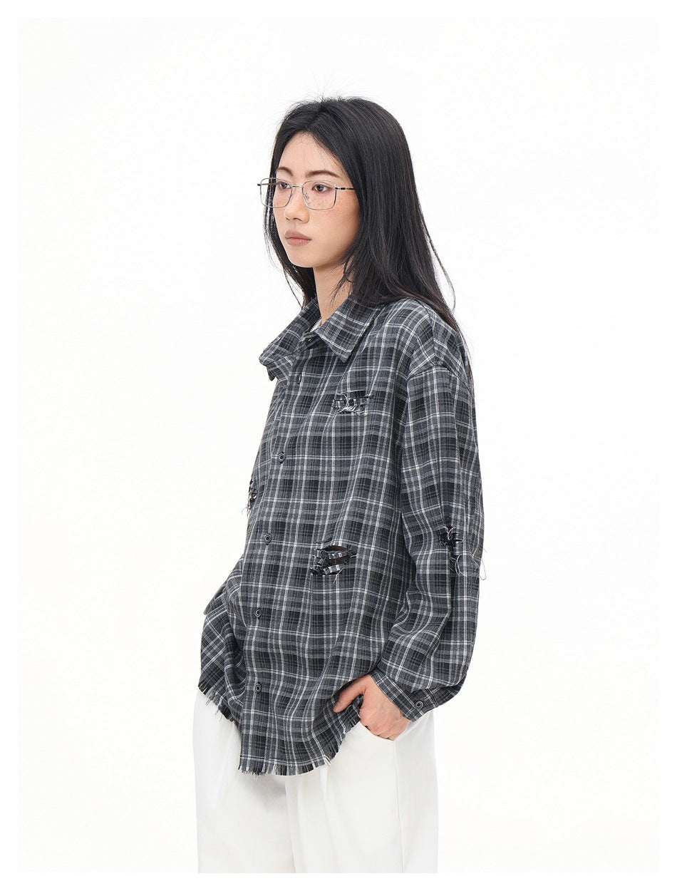 Three-quarter view of a model wearing an oversized charcoal gray plaid shirt with distressed accents and a frayed hem.