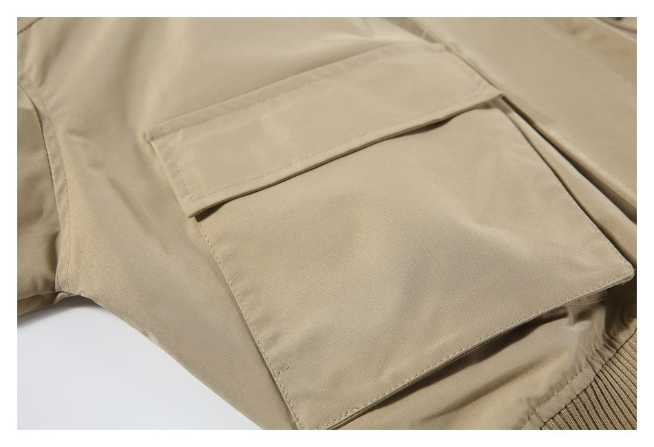 Close-up of a large flap pocket on a beige jacket.