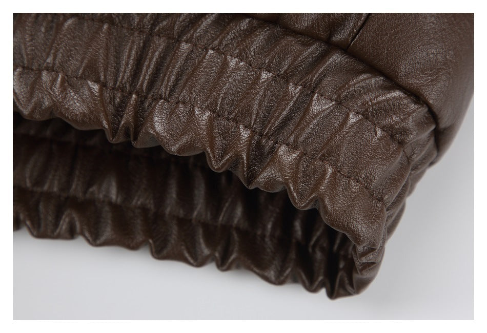 Close-up of the gathered elastic hem on a dark brown jacket.