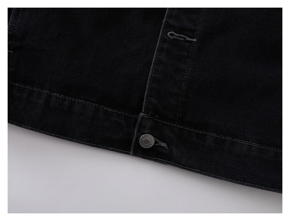 Close-up of the black denim jacket hem with a silver snap and buttonhole.