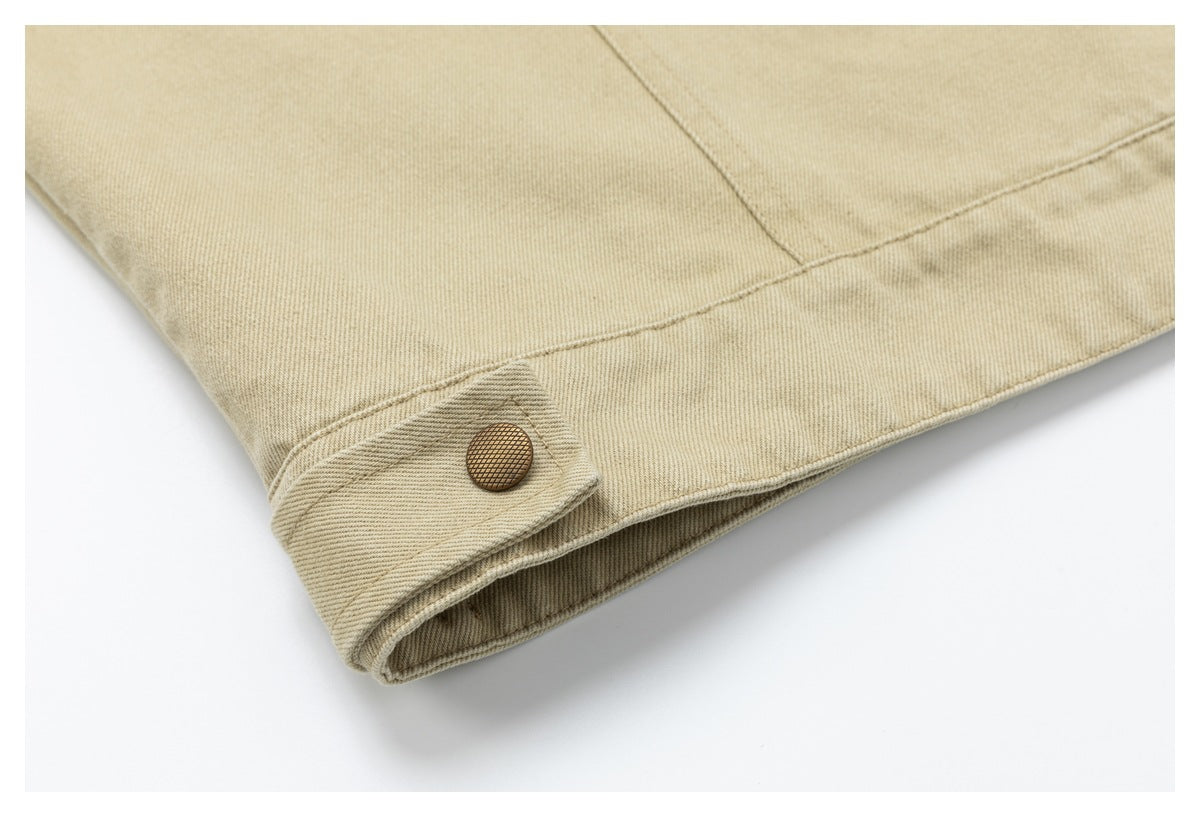 Close-up of the jacket's bottom hem and a snap-fastened side tab in sand-beige fabric.