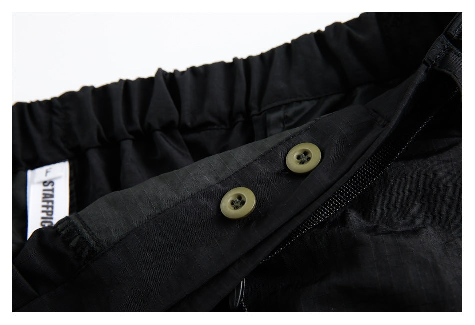 Inside waistband detail of the black skirt, showing two buttons, elastic gathering and a sewn label.