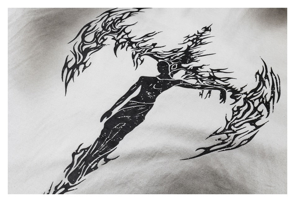 Close-up of a black flame-like graphic with a human figure printed on white fabric.