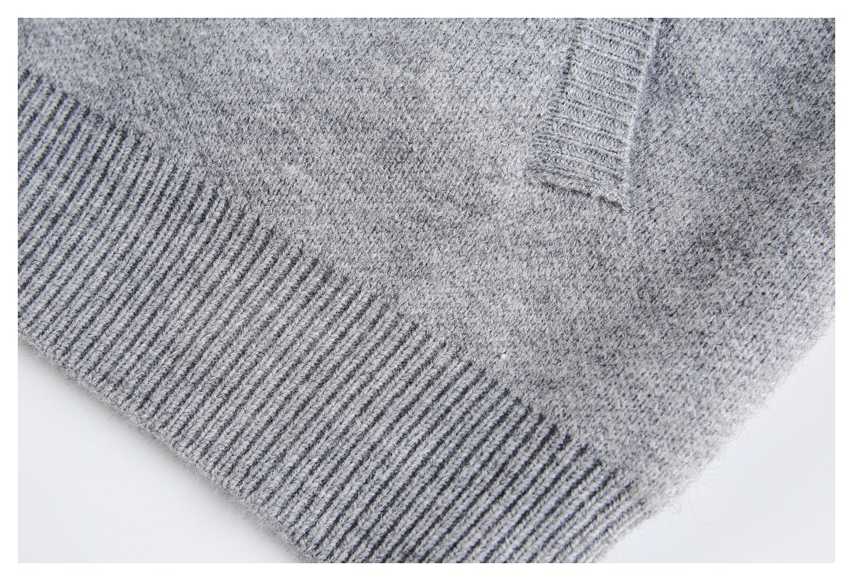 Close-up of a gray knit garment's wide ribbed edge and textured body.