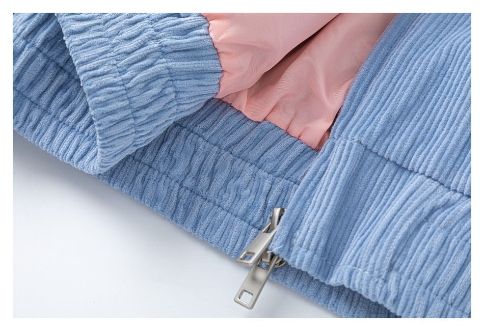 Close-up of the blue corduroy jacket's zipper, pink lining, and ribbed hem.