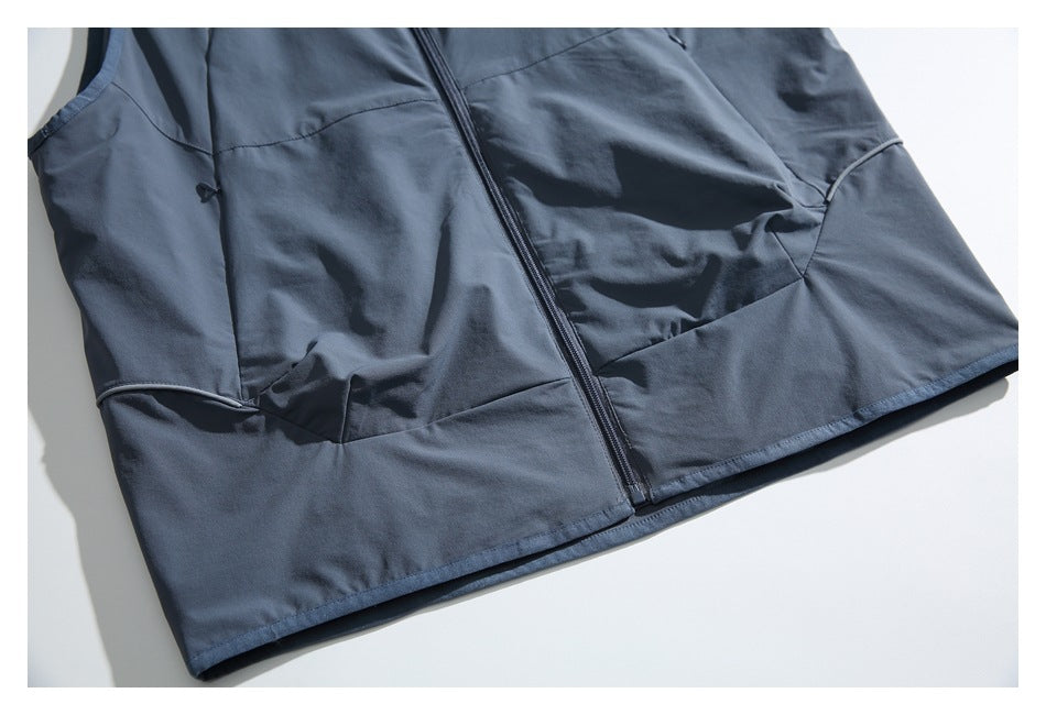 Flat lay of a slate blue-gray sleeveless zip-front vest with curved panel seams and piped details.