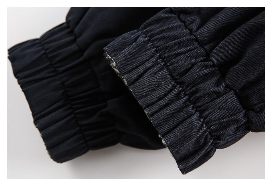 Close-up of gathered black fabric and stitched elastic bands.