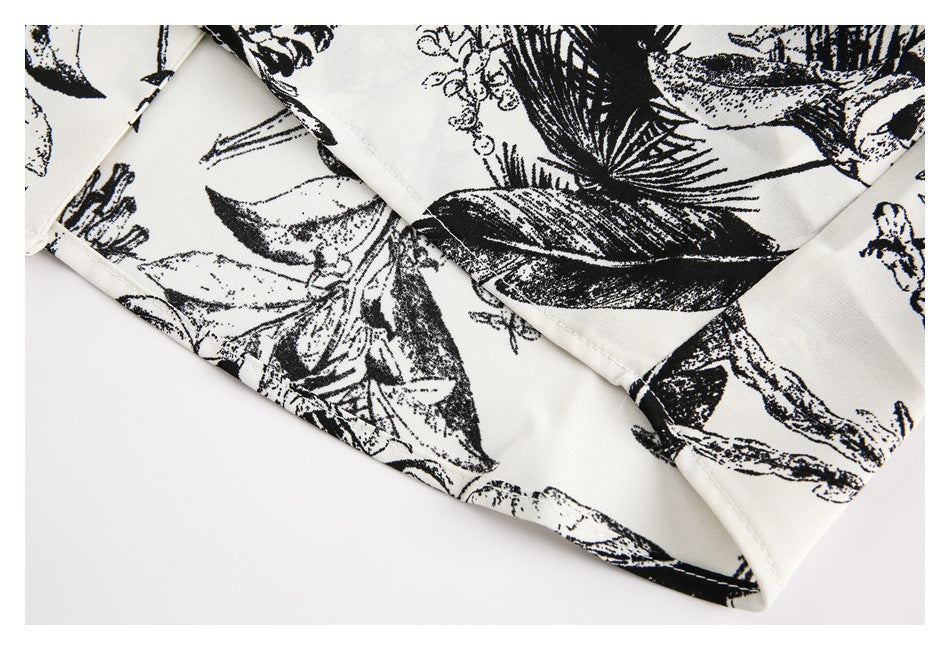 Close-up of a stitched hem on ivory fabric with a large black botanical print.