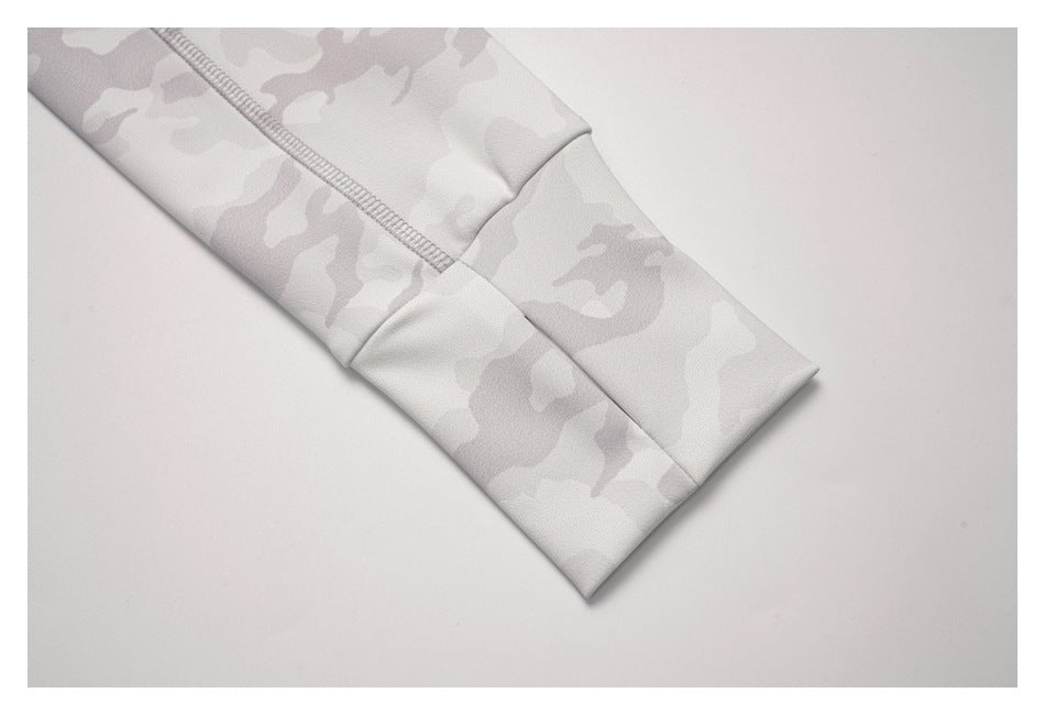 Close-up of a long sleeve cuff and seam on a light gray camouflage top.