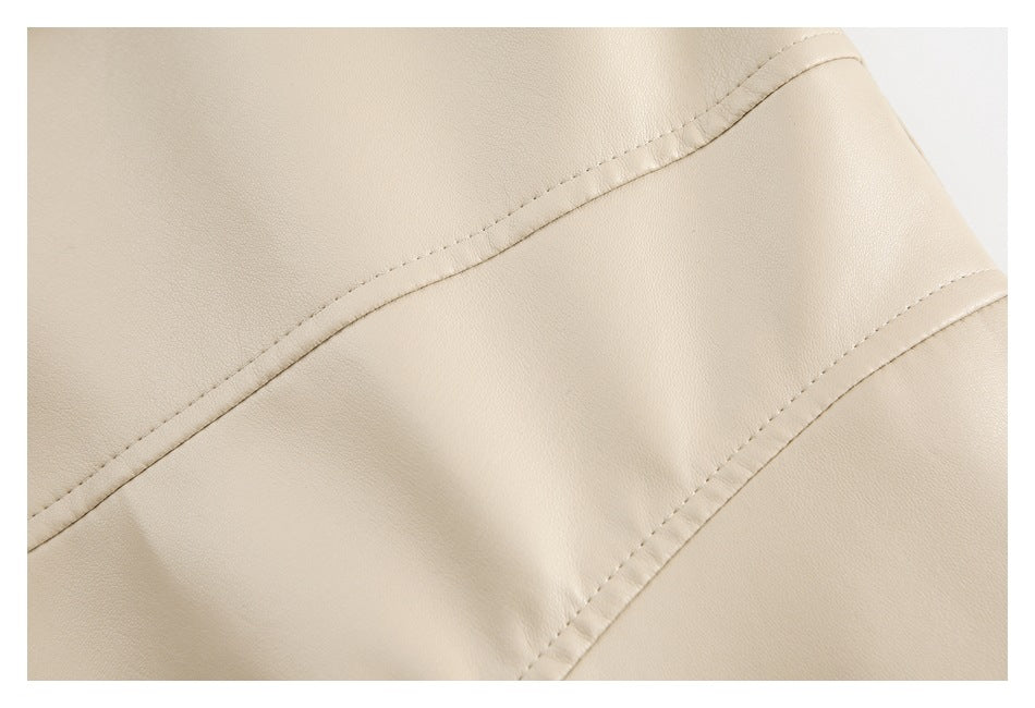 Close-up of curved stitched seam lines on the smooth cream surface of a jacket.