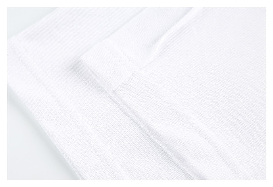 Close-up of white fabric with a stitched seam and small folded fabric tab.