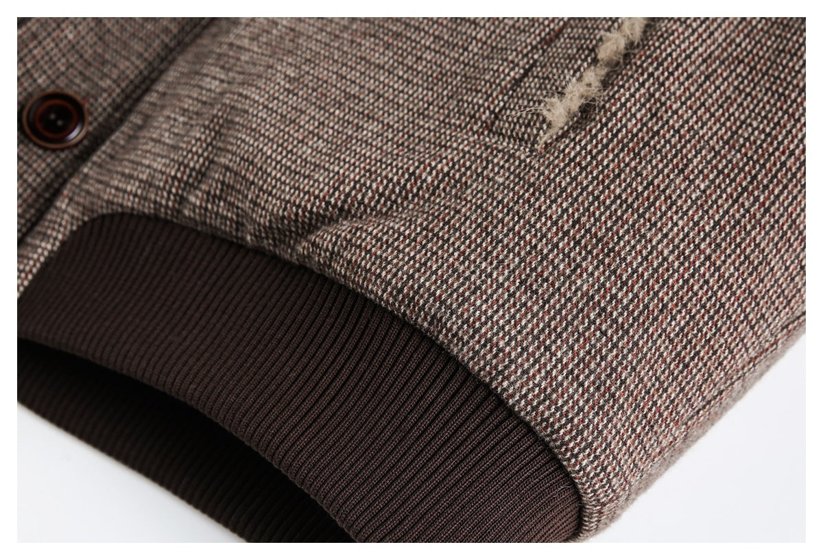 Close-up of the coat's dark brown ribbed knit cuff beside brown patterned fabric.